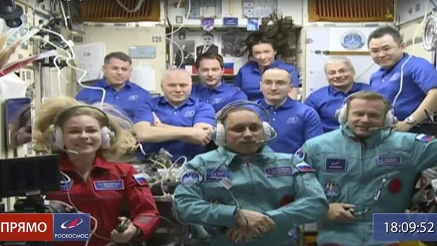 In this photo taken from video footage released by Roscosmos Space Agency, actress Yulia Peresild, left, film director Klim Shipenko, right, and cosmonaut Anton Shkaplerov sit in the first row among other participants of the mission in the International Space Station, ISS, Tuesday, Oct. 5, 2021. Russian actress Yulia Peresild and a film director Klim Shipenko rocketed to space Tuesday on a mission to make the world's first movie in orbit, a project the Kremlin said will help burnish the nation's space glory. (Roscosmos Space Agency via AP)