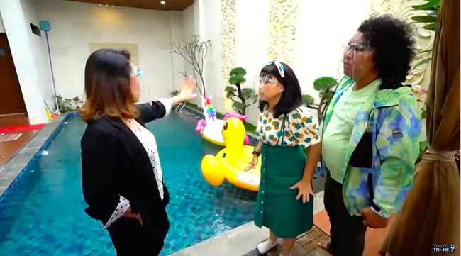 Meski tak terlalu besar, halaman belakang masih bisa diisi dengan kolam renang. Dindingnya dihiasi pahatan bernuansa Bali. (Foto: YouTube/Trans7 Official)