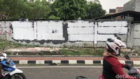 Pengendara melintas di depan mural Koruptor Dirangkul, Rakyat Kecil Dipukul yang sudah dihapus menggunakan cat putih. Mural tersebut berada di Jl Taman Bintaro Barat, Pesanggrahan.