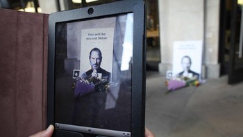 Seorang pengunjung menjepret bunga untuk Steve Jobs dengan kamera iPad. Foto: Getty Images