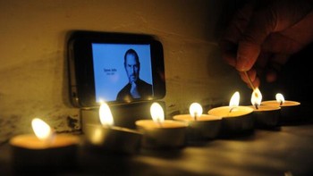 Lillin-lilin menyala di depan foto Steve Jobs. Foto: Getty Images