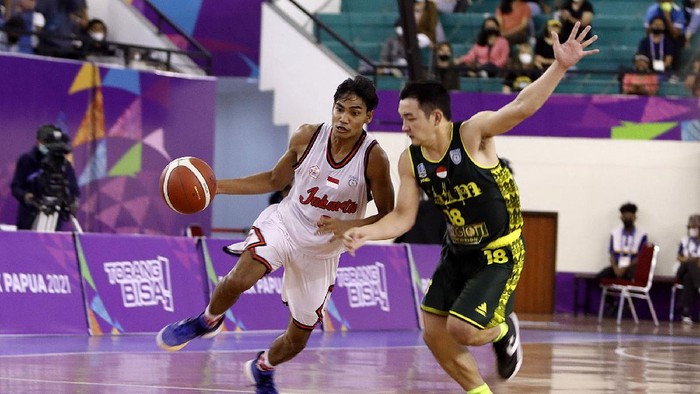 Pebasket DKI Jakarta, Yesaya Alessandro Saudale dikawal ketat oleh pebasket Jawa Timur, Andreas Marcellino Bonfillio pada pertandingan semifinal Bola Basket 5x5 Putra PON XX Papua di GOR Basket Mimika Sport Complex, Kamis (7/10/2021).