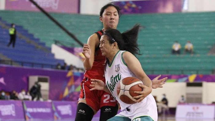 Pebasket DKI Jakarta, Shopia Rebecca (merah) berusaha menahan pergerakan pemain Jawa Timur, Christine Aldora Tjundawan pada pertandingan Semifinal Bola Basket 5x5 Putri PON XX Papua di GOR Basket Mimika Sport Complex, Kamis (7/10/2021). (Foto : PB PON XX Papua / Ady Sesotya)