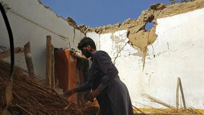 A resident removes debris of his mud house that collapsed following an earthquake in the remote mountainous district of Harnai on October 7, 2021, as around 20 people were killed and more than 200 injured when a shallow earthquake hit southwestern Pakistan in the early hours of October 7. (Photo by Banaras KHAN / AFP)
