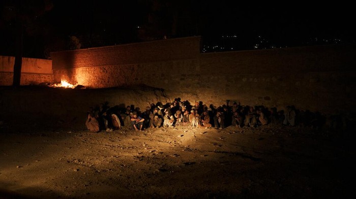 A Taliban fighter uses a flashlight to wake up a drug user detained during a police raid in Kabul, Afghanistan, Friday, Oct. 1, 2021. Now the uncontested rulers of Afghanistan, the Taliban have set their sights on stamping out the scourge of narcotics addiction, even if by force. (AP Photo/Felipe Dana)