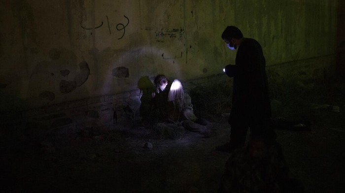Langkah Taliban Basmi Jerat Narkoba di Afghanistan A Taliban fighter uses a flashlight to wake up a drug user detained during a police raid in Kabul, Afghanistan, Friday, Oct. 1, 2021. Now the uncontested rulers of Afghanistan, the Taliban have set their sights on stamping out the scourge of narcotics addiction, even if by force. (AP Photo/Felipe Dana)