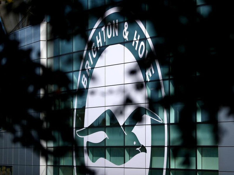 BRIGHTON, ENGLAND - SEPTEMBER 14: The Brighton and Hove Albion logo is seen through some tree branches prior to the Premier League match between Brighton & Hove Albion and Burnley FC at American Express Community Stadium on September 14, 2019 in Brighton, United Kingdom. (Photo by Dan Istitene/Getty Images)