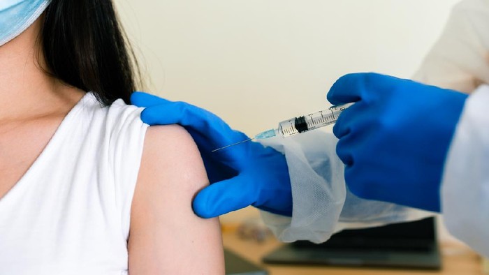 Data Vaksin Indonesia: Total Perolehan dan Jumlah yang Disuntikkan Scientists are done research on vaccine in laboratory with test tubes on Covid19 Coronavirus type for discover vaccine.