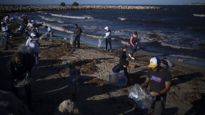 A pedestrian walks past a pile of burnt trash after an eight-day-long garbage collectors strike in Marseille, southern France, Wednesday, Oct. 6, 2021. (AP Photo/Daniel Cole)