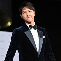 Song Joong Ki datang berbarengan dengan rekannya host Busan International Film Festival 2021, Park So Dam. Namun dia berpose di karpet merah sendirian dan tampil menawan dalam setelan jas hitam serta dasi kupu-kupu. Foto: AFP/JUNG YEON-JE