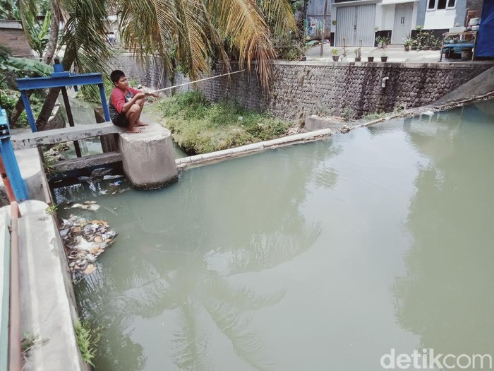 Warga memancing ikan di alur Sungai Glogok tengah kota Klaten, Kamis (7/10/2021).