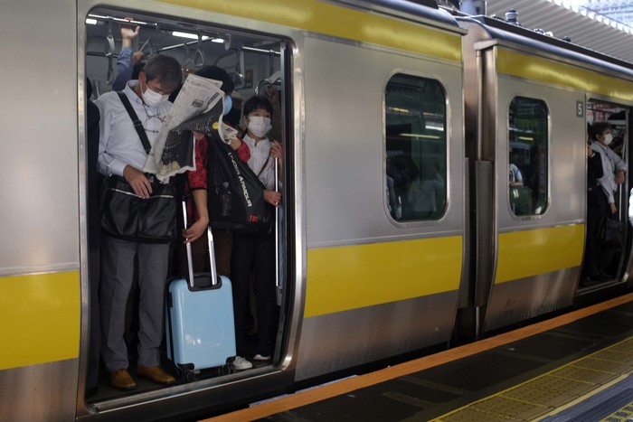 Commuters move along a crowded train station platform in Tokyo Friday, Oct. 8, 2021, the morning after a strongearthquake has shaken the Tokyo area Thursday night, temporarily halting trains and subways. (AP Photo/Kiichiro Sato)