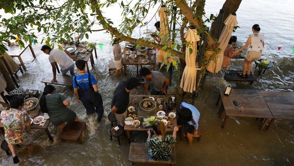 Diketahui, restoran yang berada di pinggir sungai itu tengah jadi destinasi populer warga di Negeri Seribu Pagoda. Bukan tanpa alasan, mereka datang ke sana untuk merasakan sendiri makan di tengah banjir.  