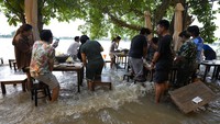 Tak sedikit pengunjung yang mengabadikan momen mereka makan di tengah banjir lewat ponsel masing-masing.  