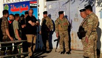 Tentara berbaris menunggu giliran mencoblos dalam pemilu parlemen di Kota Baghdad, Irak (8/10). Pasca rezim Saddam Hussein, Irak menganut sistem republik parlementer. (AP Photo/Khalid Mohammed)