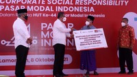 Ketua Dewan Komisioner Otoritas Jasa Keuangan (OJK) Wimboh Santoso (kiri) menyaksikan Direktur Utama PT Kustodian Sentral Efek Indonesia (KSEI) Uriep Budhi Prasetyo (kedua kiri) menyerahkan secara simbolis bantuan kepada Pimpinan Pondok Pesantren Matholil Anwar, K.H. Ahmad Taufik (kedua kanan) dalam rangka peringatan 44 tahun diaktifkannya kembali Pasar Modal Indonesia.