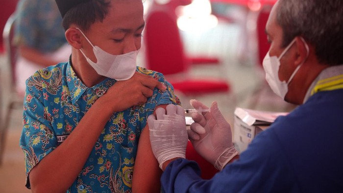Ketua Dewan Komisioner Otoritas Jasa Keuangan (OJK) Wimboh Santoso (kiri) menyaksikan Direktur Utama PT Kustodian Sentral Efek Indonesia (KSEI) Uriep Budhi Prasetyo (kedua kiri) menyerahkan secara simbolis bantuan kepada Pimpinan Pondok Pesantren Matholil Anwar, K.H. Ahmad Taufik (kedua kanan) saat acara  pemberian bantuan sosial dan vaksinasi di kompleks Pesantren Matholil Anwar, Lamongan, Jawa Timur,  Jumat (8/10/2021). Otoritas Jasa Keuangan bersama PT Bursa Efek Indonesia (BEI), PT Kliring Penjaminan Efek Indonesia (KPEI), dan PT Kustodian Sentral Efek Indonesia (KSEI) menyelenggarakan rangkaian kegiatan sosial dan vaksinasi yang bertujuan untuk membantu masyarakat yang membutuhkan bantuan di tengah kondisi pandemi dan juga dalam rangka peringatan 44 tahun diaktifkannya kembali Pasar Modal Indonesia. ANTARA FOTO/Umarul Faruq/aww.