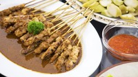 Klasik dan selalu dicari, inilah sate ayam Madura yang jadi favorit banyak orang Indonesia. Ciri khasnya memakai irisan daging ayam yang tipis dengan celupan saus kacang dan kecap manis. Kamu bisa bikin sendiri sate ayam Madura dengan resep berikut. Foto: iStock 