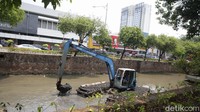 Walau panas teris menyengat, petugas tetap bersemangat demi mencegah banjir.