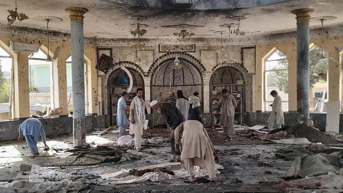 People view the damage inside of a mosque following a bombing in Kunduz, province northern Afghanistan, Friday, Oct. 8, 2021. A powerful explosion in the mosque frequented by a Muslim religious minority in northern Afghanistan on Friday has left several casualties, witnesses and the Talibans spokesman said. (AP Photo/Abdullah Sahil)