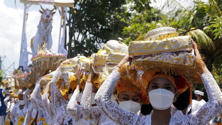 Ngaben Skala Besar di Bali Kembali Digelar Balinese women line up as they carry offerings during a cremation ceremony of Hindu priest Ida Pedanda Nabe Gede Dwija Ngenjung in Denpasar, Bali, Indonesia on Friday, Oct. 8, 2021. (AP Photo/Firdia Lisnawati)