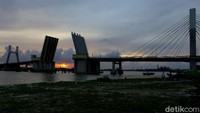 Saat matahari terbenam adalah waktu yang tepat untuk menikmati keindahan senja di balik Jembatan Emas tersebut. Terlebih saat jembatan itu mengangkat dan tertutup.