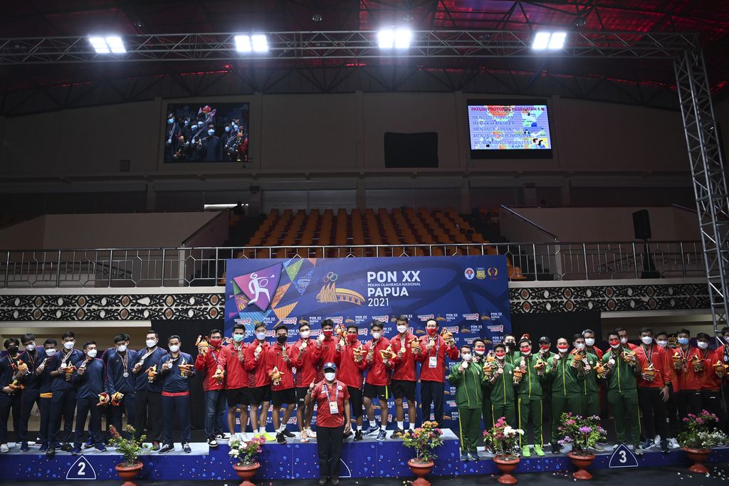 Tim bulu tangkis putra DKI Jakarta (tengah), tim bulu tangkis putra Jawa Barat (kiri), tim bulu tangkis putra Jawa Tengah dan Jawa Timur (kanan) berfoto bersama usai Upacara Penghormatan Pemenang final beregu putra PON Papua di GOR Waringin Kotaraja, Kota Jayapura, Papua, Sabtu (9/10/2021). Tim bulu tangkis DKI Jakarta meraih medali emas, disusul tim Jawa Barat meraih medali perak dan tim Jawa Tengah dan Jawa Timur meraih medali perunggu. ANTARA FOTO/Nova Wahyudi/wsj.