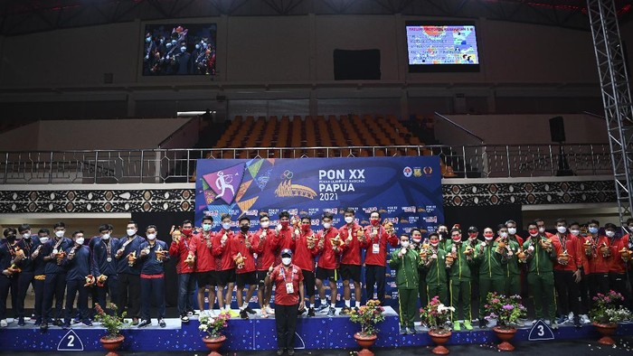 Tim bulu tangkis putra DKI Jakarta (tengah), tim bulu tangkis putra Jawa Barat (kiri), tim bulu tangkis putra Jawa Tengah dan Jawa Timur (kanan) berfoto bersama usai Upacara Penghormatan Pemenang final beregu putra PON Papua di GOR Waringin Kotaraja, Kota Jayapura, Papua, Sabtu (9/10/2021). Tim bulu tangkis DKI Jakarta meraih medali emas, disusul tim Jawa Barat meraih medali perak dan tim Jawa Tengah dan Jawa Timur meraih medali perunggu. ANTARA FOTO/Nova Wahyudi/wsj.