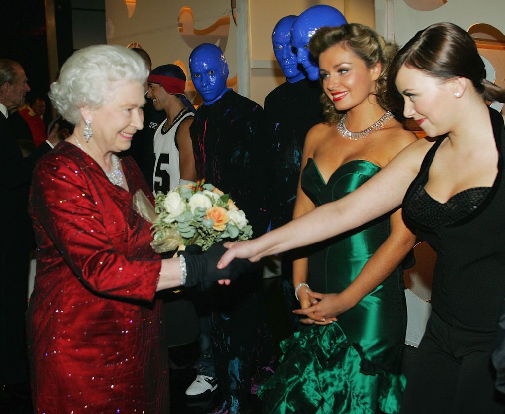 CARDIFF, UNITED KINGDOM - NOVEMBER 21:  (NO PUBLICATION IN UK MEDIA FOR 28 DAYS) HM Queen Elizabeth II meets singers Charlotte Church (R) and Katherine Jenkins as The Blue Man Group look on, backstage following the Royal Variety Performance, November 21, 2005 in Cardiff, Wales.  (Photo by Daily Mirror-Pool/Anwar Hussein Collection/Getty Images)