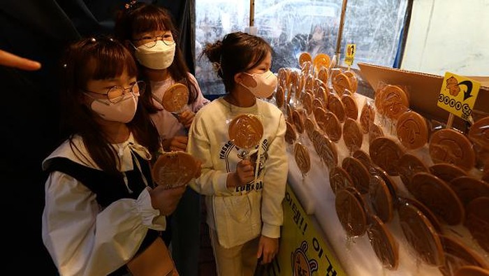 SEOUL, SOUTH KOREA - OCTOBER 09: People buy Dalgona candy at a shop on October 09, 2021 in Seoul, South Korea. Dalgona, a South Korean sweet featured as one of the lethal challenges in the Netflix TV series Squid Game has become a global craze, boosting business for South Korean street vendors who sell the Dalgona candy. (Photo by Chung Sung-Jun/Getty Images)