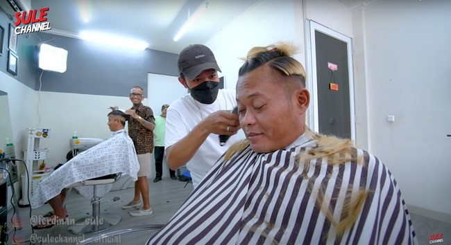 Sesampainya di tempat potong rambut, Sule pun meminta agar rambutnya dipotong pendek karena dia mengaku sudah bosan dengan rambut panjangnya. Sebelumnya Sule pun sempat melakukan polling di Instagram. Hasilnya, 60% memilih Sule untuk memotong rambutnya jadi lebih pendek. Foto: YouTube/SULE Channel