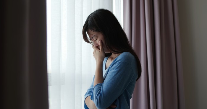 1253762685 asian depression sad woman is standing by windows alone at home and thinking negative thoughts