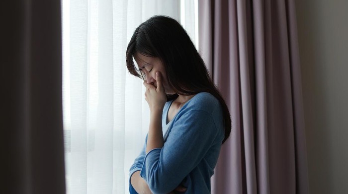 1253762685 asian depression sad woman is standing by windows alone at home and thinking negative thoughts