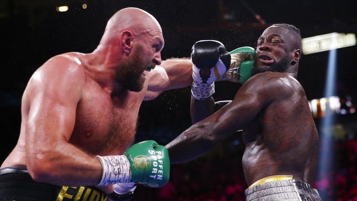 Tyson Fury, of England, lands a left to Deontay Wilder in a heavyweight championship boxing match Saturday, Oct. 9, 2021, in Las Vegas. (AP Photo/Chase Stevens)