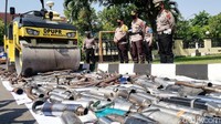 Petugas memusnahkan knalpot brong menggunakan alat berat.