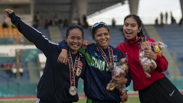 Pelari Sumatera Selatan Sri Mayasari (tengah), pelari Bengkulu Hasruni (kiri), dan pelari DKI Jakarta Jeany Nuraini (kanan) berpose usai pengalungan medali lari 200 meter putri PON Papua di Stadion Atletik Mimika Sport Center, Kabupaten Mimika, Papua, Senin (11/10/2021). Hasruni meraih medali perak, sementara pelari Sumatera Selatan Sri Mayasari meraih medali emas dan pelari DKI Jakarta Jeany Nuraini meraih medali perunggu. ANTARA FOTO/Aditya Pradana Putra/tom.