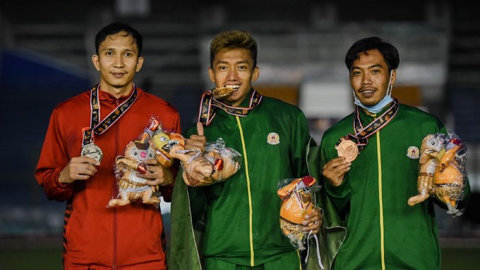 Atlet lompat tinggi galah Jawa Timur Teuku Tegar Abadi (tengah) DKI Jakarta  (kiri) dan Jawa Timur Dedi Irawan menunjukkan medali yang diterimanya seusai mengikuti nomor lompat tinggi galah putra PON XX Papua di Stadion ATletik, Mimika Sport Complex, Senin (11/10/2021). PB PON XX Papua / Rommy Pujianto