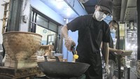 Mantan Penyidik KPK Juliandi Tigor Simanjuntak memasak nasi goreng di warung wilayah Pondok Melati, Bekasi, Senin (11/10/2021).