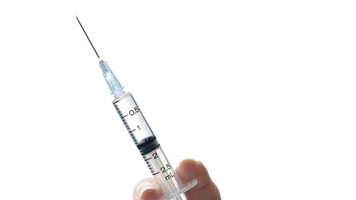 The doctor prepares the syringe with the cure for vaccination.