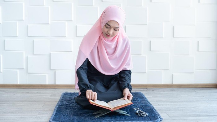 Young beautiful Muslim Woman Praying In Mosque.