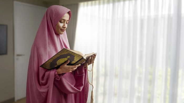 Young beautiful Muslim Woman Praying In Mosque.