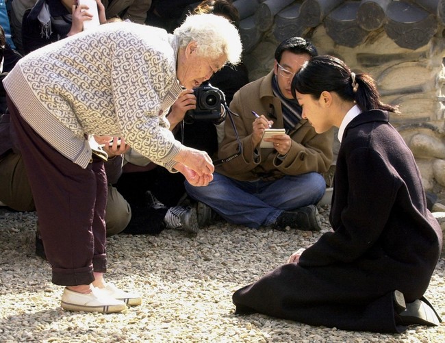 Pemotretan itu menuai banyak protes dan membuat Lee Seun-yeon harus menyampaikan maaf dengan bersimpuh di depan wanita yang pernah menjadi ‘comfort women. Dia sampai dijuluki sebagai kriminal gara-gara foto menjadi budak seks tersebut. Foto: dok. AFP