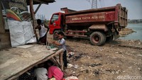 Truk milik Dina Tata Air DKI Jakarta siaga untuk mengangkut tanah dari lokasi waduk.