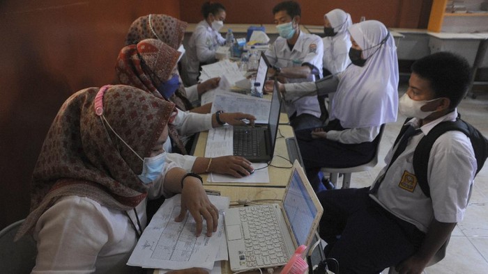 Petugas menyuntikkan vaksin COVID-19.pada salah satu pelajar SMP di Negeri 13 Palembang, Sumsel, Selasa (12/10/2021). Pemerintah Kota Palembang menargetkan sebanyak 192.671 pelajar di Kota Palembang untuk mendapatkan vaksin COVID-19. ANTARA FOTO/Feny Selly/hp.