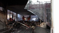 Petugas Dinas Pemadam Kebakaran Kota Surabaya melakukan pembasahan ruangan yang terbakar di kompleks Kantor Kementerian Pekerjaan Umum dan Perumahan Rakyat, Surabaya.