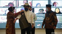 Menteri Sosial Tri Rismaharini memakaikan topi dan ropi mahasiswa pejuang muda Kampus Merdeka di Kemensos RI, Jakarta, Rabu (13/10/2021).