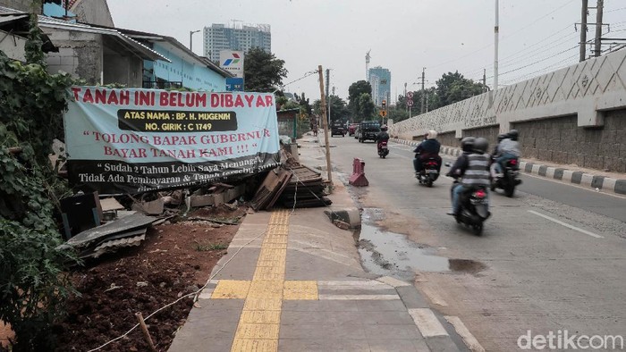 Nah Loh! Spanduk 'Tanah Belum Dibayar' Mejeng di JPO Tapal Kuda Sejumlah spanduk bertulisakan 'Tanah Ini Belum Dibayar' terpampang di sejumlah bidang tanah di dekat Flyover tapal kuda Tanjung Barat.