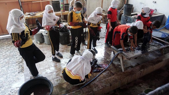 Sejumlah pelajar Sekolah Dasar (SD) melakukan proses pelunturan pewarna batik saat belajar membatik di Museum Batik Pekalongan, Jawa Tengah, Rabu (13/10/2021). Dinas Pendidikan Kota Pekalongan menggelar pelatihan batik bagi 510 siswa SD di Pekalongan untuk mencetak generasi muda nantinya agar menjadi pengusaha bidang batik dan sebagai upaya mendorong generasi muda dalam melestarikan batik. ANTARA FOTO/Harviyan Perdana Putra/aww.