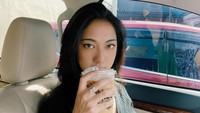 Segelas es kopi menemani Anindita di mobil. Tak lupa ia mengabadikan foto dengan outfitnya yang simpel tapi keren.
