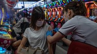 Seorang vaksinator menyuntikan vaksin COVID-19 kepada warga di tempat bermain pachinko yang berada di kawasan Osaka, Jepang, Rabu (13/10/2021).